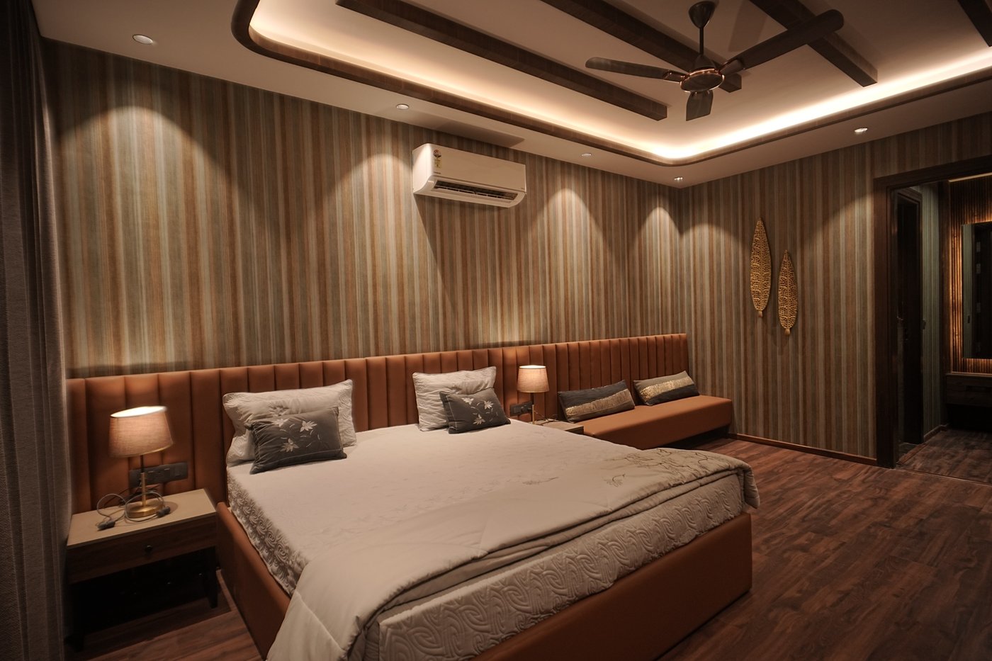 Luxury villa master bedroom in Dehradun with leather headboard, wood beam ceiling, ambient lighting