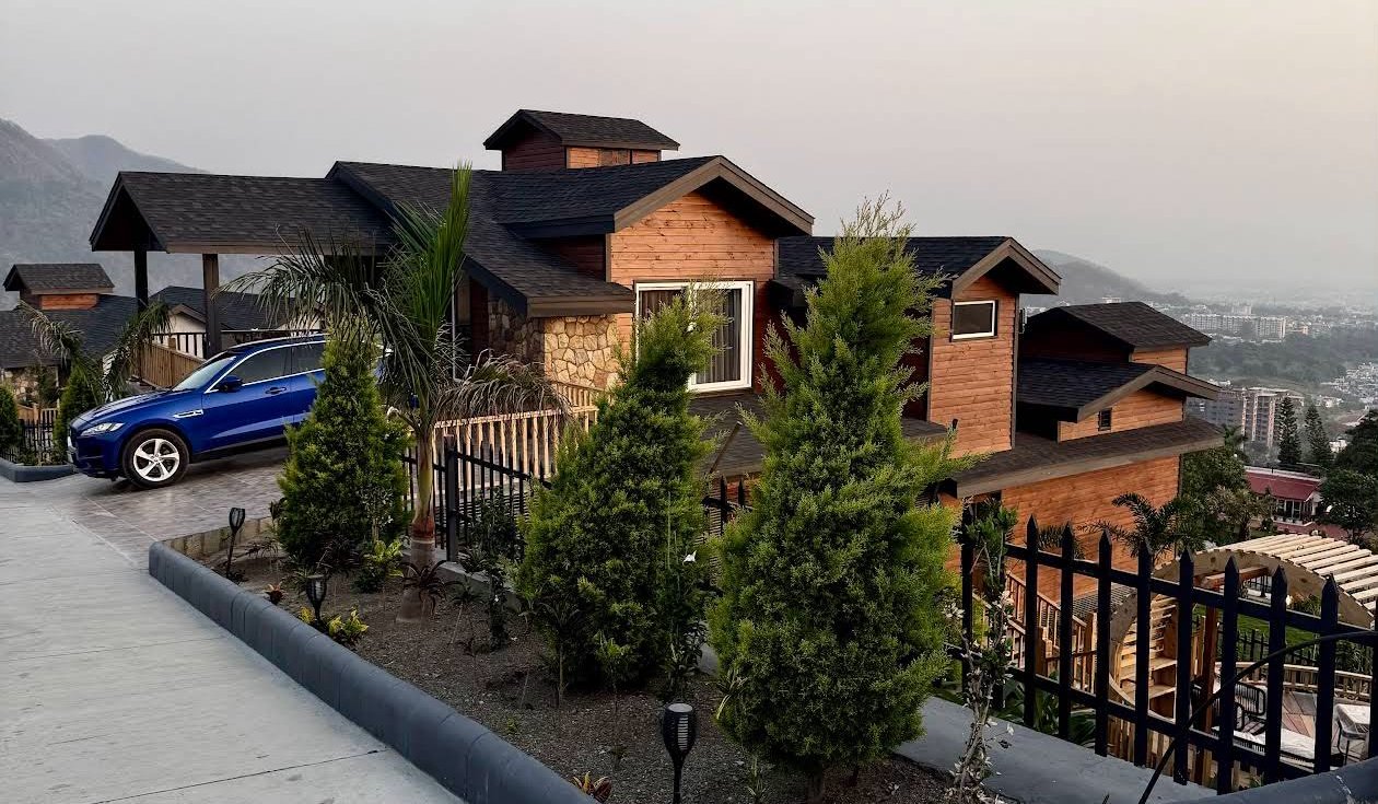 Hillcrest premium gated society villas with car in driveway and Shivalik mountains in the background